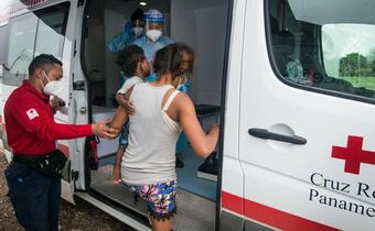 A woman on the move with her son climb into a mobile Humanitarian Service Point vehicle operated by the Panamanian Red Cross in San Vicente, Darién to receive medical attention following a gruelling walk through the Darien Gap in search of a better life.