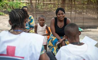 A mother and her child speak to volunteers from the DR Congo Red Cross as part of an early warning system to monitor for Ebola in Equateur Province in June 2018.