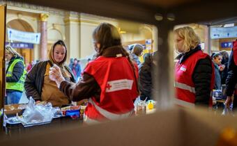 A woman fleeing conflict in Ukraine speaks to Hungarian Red Cross volunteers at a Humanitarian Service Point they'd set up in Keleti train station to welcome people arriving from Ukraine and provide support.