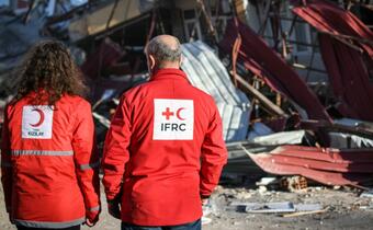 Turkish Red Crescent and IFRC staff stand side by side as they survey damage caused by the devastating earthquakes in southeast Turkiye on 6 February 2023.
