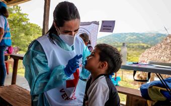 A Venezuelan Red Cross health worker provides a health check up on a young boy in a rural village in Portuguesa state.