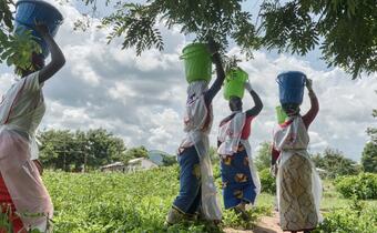 Malawi Red Cross Society volunteers carry water from a borehole to a cholera treatment centre outside Mangochi in south-eastern Malawi in February 2023.