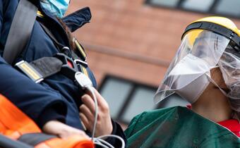 An Italian Red Cross health volunteer helps transport a patient with suspected COVID-19 to hospital in Milan in March 2020.