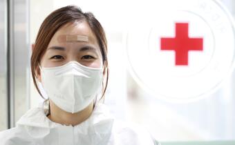 A Korea Red Cross Society medical worker wears a mask in a hospital where she's treating patients with COVID-19 in February 2022.