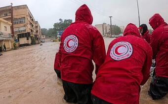 A team of Libyan Red Crescent volunteers wade through flood waters caused by Storm Daniel in September 2023 to reach affected communities.