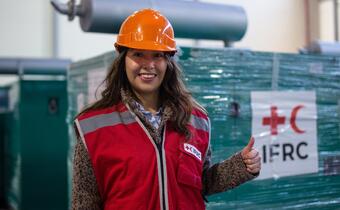 An IFRC worker gives a thumbs up as a batch of generators arrives in Lviv, Ukraine in January 2023 to help restore power to hospitals, public facilities and homes impacted by the international armed conflict.