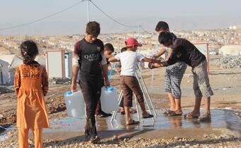 People who are impacted by crisis are particularly vulnerable to extreme heat. These Iraqi children were displaced by conflict. They gather around water taps in a camp for internally displaced people in order to cool down and fill up their water jugs.