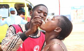 A volunteer with the Angola Red Cross provides an oral cholera vaccine during a community outreach in Luanda Province. 