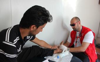A migrant who swam from Turkey to Greece gets help from the Hellenic Red Cross Society.