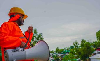 A community volunteer in Bangladesh provides early warning messages to residents in camps for displaced people.