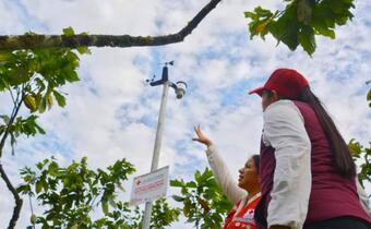 Josselyn Balcázar explains to the Prefect of Zamora Chinchipe, Karla Reátegui, how the SATHEOBROMA Early Warning System works. 