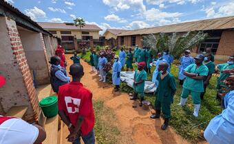 A DRC Red Cross Safe and Dignified Burial (SDB) specialist briefs response teams in Mongbwalu as part of ongoing Ebola response activities. Regular briefings help strengthen operational readiness, reinforce key procedures, and support personnel working in challenging field conditions.