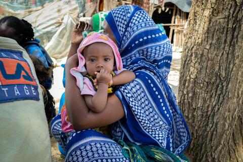 Una madre sostiene a su hija en un campamento para desplazados internos en Koneba, Etiopía