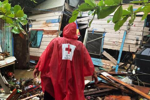 Un voluntario de la Cruz Roja Guatemalteca llega a una vivienda gravemente dañada por el huracán Eta en noviembre de 2020
