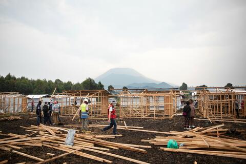 Des volontaires de la Croix-Rouge de la RDC et des employés de l'IFRC construisent des abris temporaires après l'éruption du Mont Nyiragongo en mai 2021.