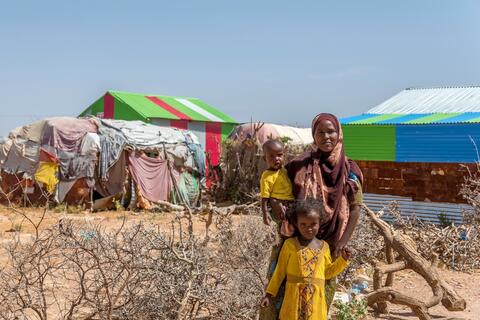 A mother and her two children in Ainabo camp, Somaliland stand together having just attended a mobile health clinic run by the Somali Red Crescent Society which provides basic health services to remote regions