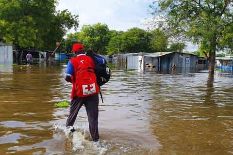 A South Sudan Red Cross volunteer walks through flood water in Bor in September 2020 to reach flood-affected communities and plan a distribution of essential household items