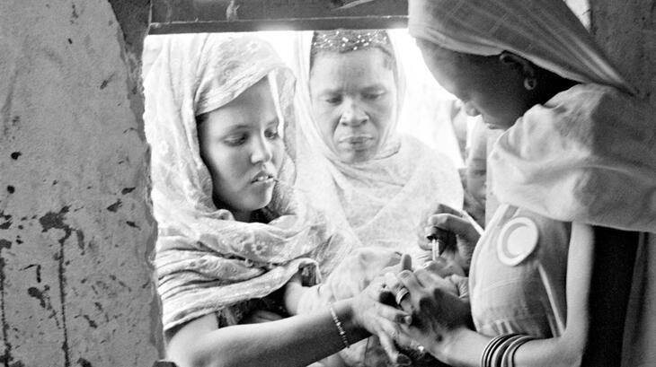 Una voluntaria que trabaja en un centro médico de la Media Luna Roja en Mauritania en 1976 brinda servicios de salud a una comunidad remota