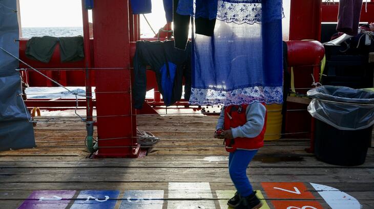 A young survivor plays hopscotch on board the deck of the boat, Ocean Viking. On 16 December 2021, the boat's crew - made up of people from SOS Mediterranee and the IFRC - rescued 114 people from a rubber boat in distress in international waters off the coast of Libya. Survivors were safely disembarked in Trapani, Sicily eight days later on Christmas Eve where they were supported by Italian Red Cross volunteers.