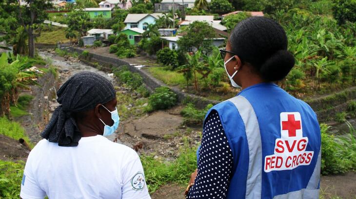 St Vincent and the Grenadines Red Cross team members look out over the community of Spring Village where ash continues to be removed following the eruption of La Soufriere Volcano in April 2021. One year on and life is slowly starting to return to normal. Red Cross teams have been providing a wide range of support to affected communities.