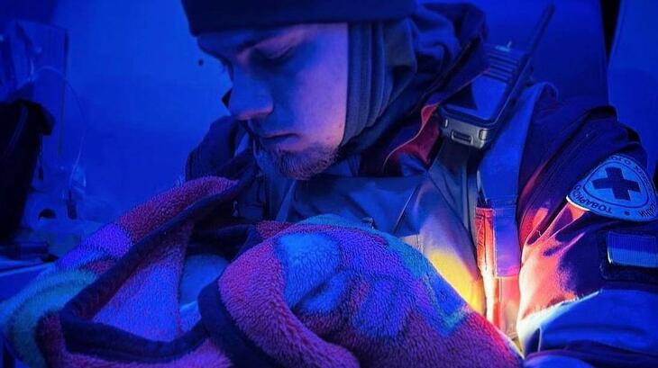 Une volontaire de la Croix-Rouge ukrainienne prend soin d'un petit bébé lors du déploiement d'une équipe médicale d'urgence en janvier 2023. Un an après l'escalade du conflit en Ukraine, la dévastation continue d'affecter tous les aspects de la vie des gens.