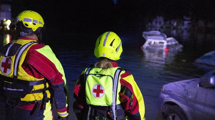 Italian Red Cross volunteers in Emilia-Romagna, Italy look at a submerged car in flood waters in May 2023. Volunteers have been busy performing search and rescue and providing first aid and psychosocial support to those affected by the heavy flooding.