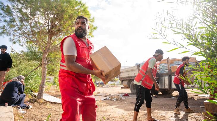 Libyan Red Crescent teams form a line to quickly pass boxes of aid items for distribution to families who have lost everything due to Storm Daniel in September 2023.