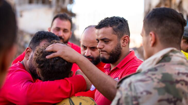Des volontaires du Croissant-Rouge libyen étreignent et réconfortent un garçon qui a survécu aux terribles inondations provoquées par la tempête Daniel.