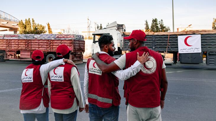 Moroccan Red Crescent volunteers hug after loading up 15 trucks with tents, blankets, mattresses, jerry cans, clothes and food for distribution to families affected by the September 8 earthquake.