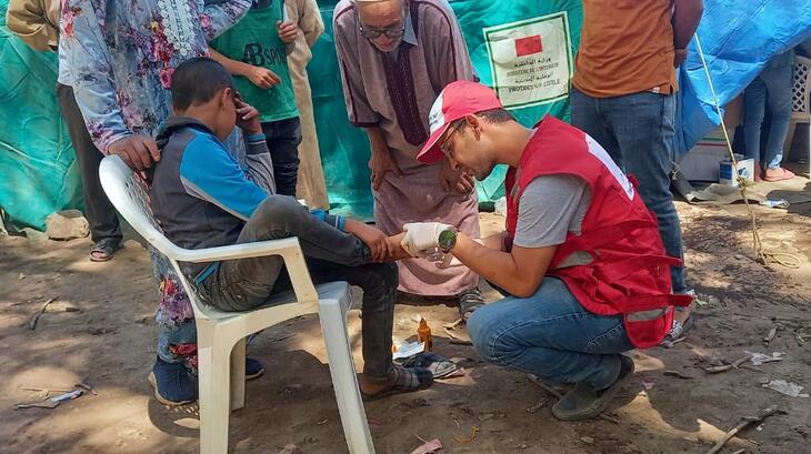 Un volontaire du Croissant-Rouge marocain donne les premiers soins à un jeune garçon qui s'est blessé au pied lors du tremblement de terre du 8 septembre.