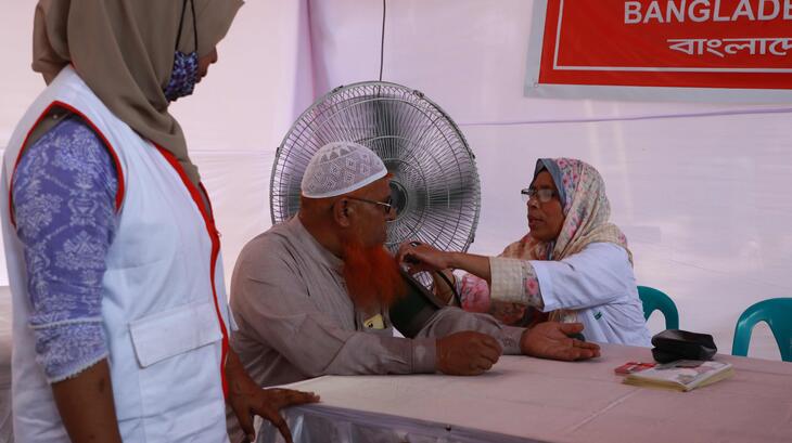 Bangladesh Red Crescent volunteers give a blood pressure test to a man at a cooling station set up by the Bangladesh Red Crescent in Dhaka, Bangladesh.