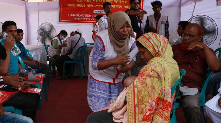A volunteer for the Bangladesh Red Crescent checks on a woman and her baby at a cooling station set up by the Red Crescent in Dhaka, Bangladesh. Infants are particularly susceptible to extreme heat and side effects such as dehydration.