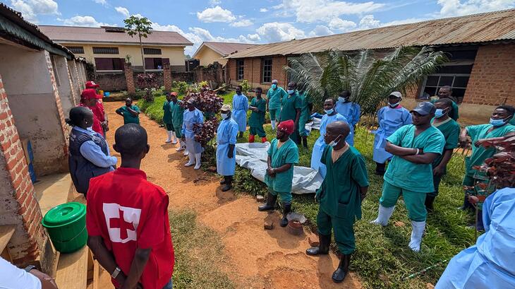 A specialist from the Red Cross of the Democratic Republic of the Congo conducts a safety briefing for response teams in Mongbwalu in June 2026 to reinforce crucial Safe and Dignified Burial procedures during ongoing Ebola response operations.